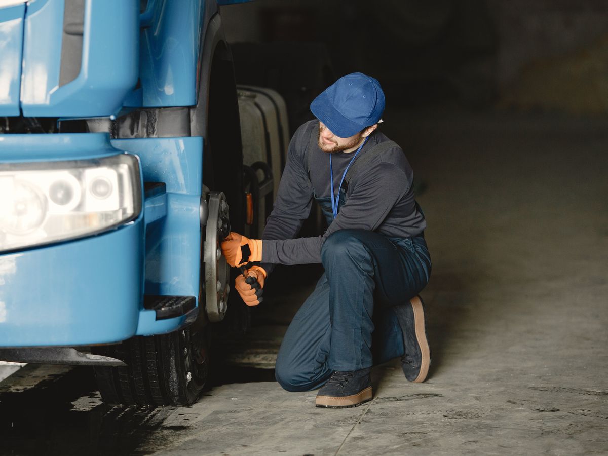 Mechanic loosening lug nuts on a truck wheel